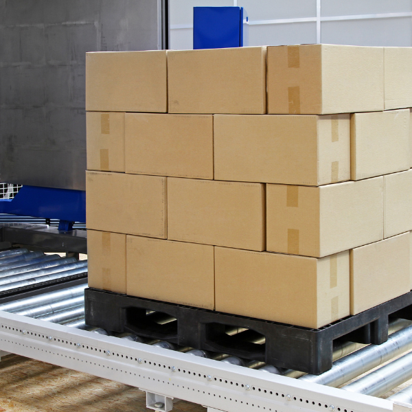 Heavy-duty plastic pallet with stacked cardboard boxes demonstrating load capacity