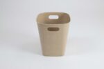 Rectangular waste bin in beige plastic with subtle floral embossing and built‑in side carry handles